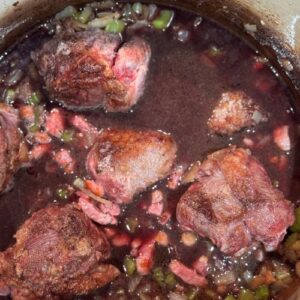 Slow cooked beef shin with red wine, baby carrots & onions