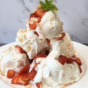 A showstopper dessert Truly Yummy Eton mess meringues, whipped plant-based cream and strawberries piled high in the form of a pyramid with a sprinkling of toasted flaked almonds