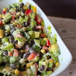salad bowl filled with Mexican Salad - avocado, black beans, peppers, sweetcorn in a mayonnaise dressing