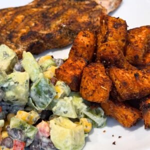 Sweet potato cubes cooking in a spicy coating served with cajun chicken and truly yummy Mexican salad